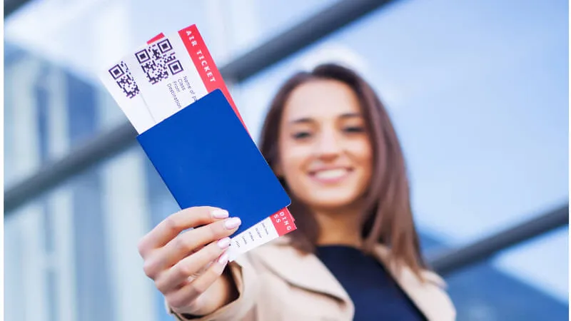 Pasaportunu ve uçuş kartını gösteren gezgin: vize için uçuş rezervasyonu